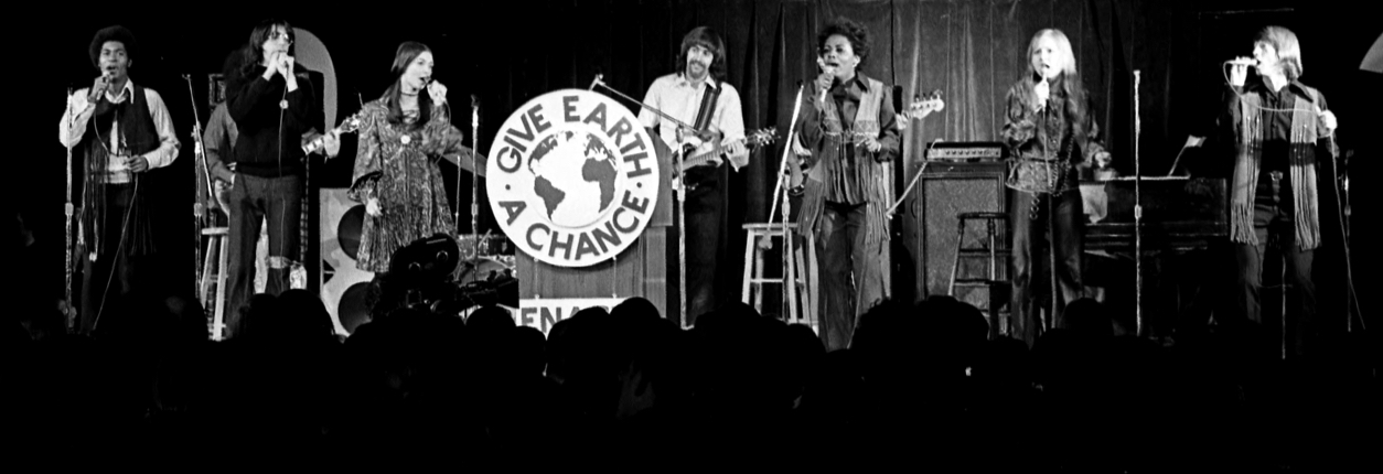 An image of a group of musicians singing, dancing, and playing their instruments